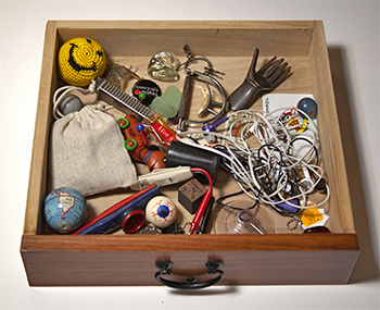 Close up photo of one of three drawers containing the objects dipicted in the photographs exhibited.